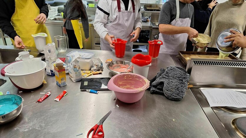 Arbeitsplatz voller Schüsseln und Materialien in der Küche der Schüler:innenfirma